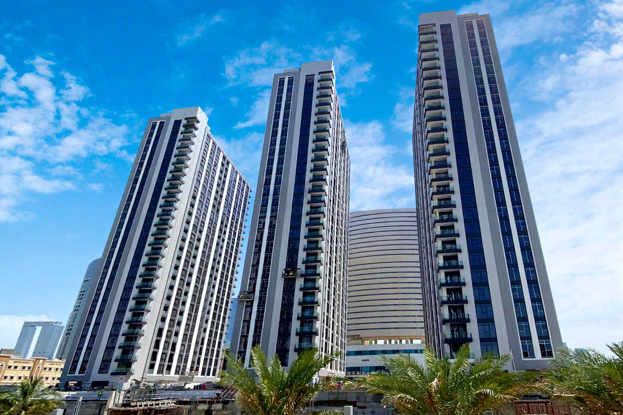 Canal promenade at The Bridges Reem Island highlighting waterfront walking paths and luxury apartment community living.