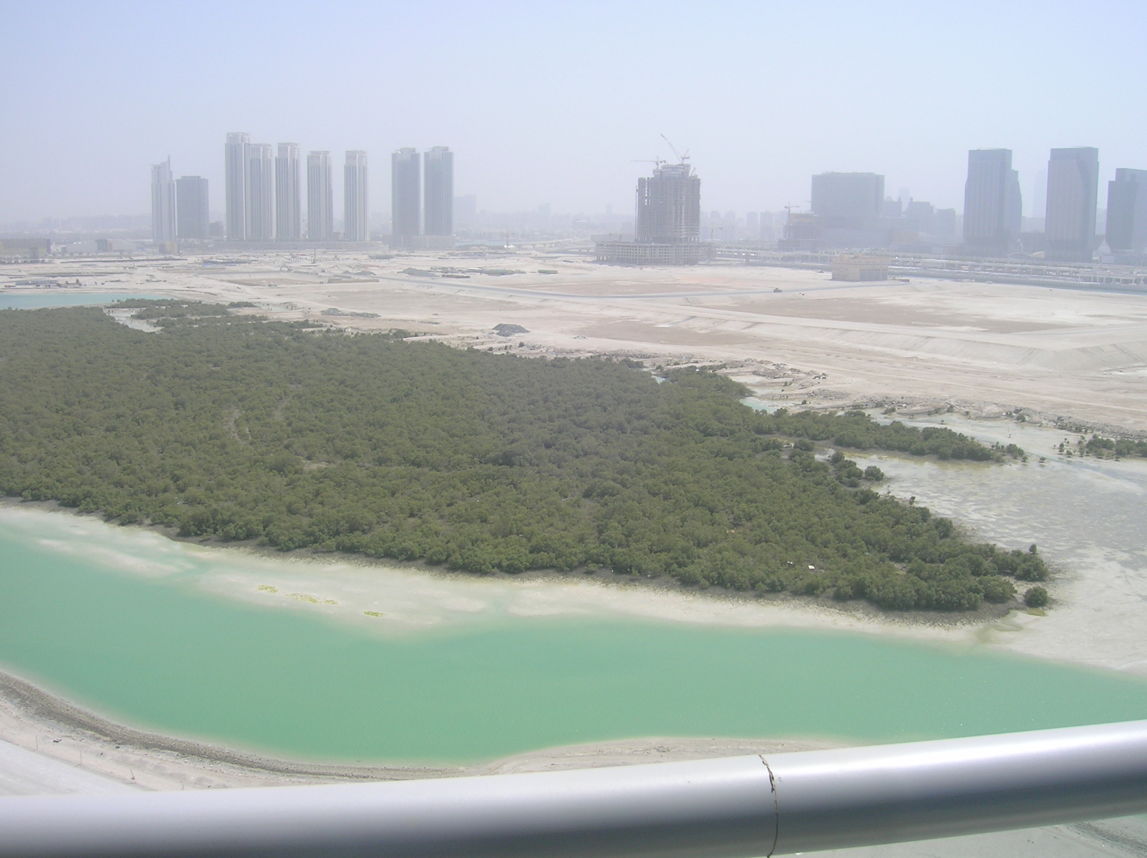 Oceanscape by Damac exterior entrance driveway on Al Reem Island, Abu Dhabi, framed by palm-lined landscaping and water features